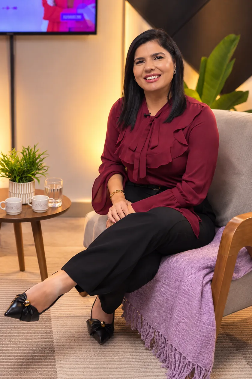 Tatiane Dib sentada em uma poltrona, sorrindo